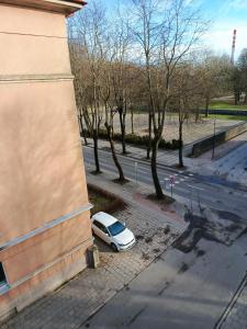 ein weißes Auto, das neben einem Gebäude parkt in der Unterkunft Parko apartamentai Self check in in Klaipėda