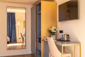 Zimmer mit einem Schreibtisch und einem Spiegel in der Unterkunft Hotel Rovereto in Rovereto
