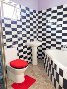 a bathroom with a toilet and a sink and a tub at The Crescent Byo in Bulawayo