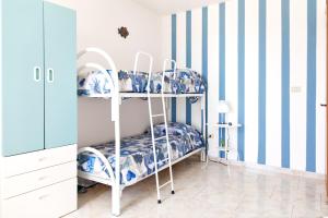 a bunk bed in a room with blue and white stripes at Casa Tridente - Meravigliosa villa sul mare in Torre Mozza