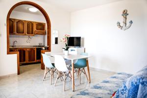 a kitchen and dining room with a table and chairs at Casa Tridente - Meravigliosa villa sul mare in Torre Mozza