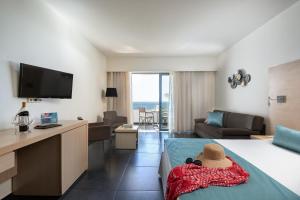 a hotel room with a bed and a living room at Atlantica Mikri Poli Kos in Kardamaina