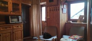 Cette chambre dispose de deux chaises, d'une télévision et d'une fenêtre. dans l'établissement Baita nonno Guido, à Moncenisio