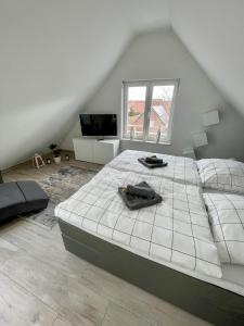 a bedroom with a large white bed in a attic at Ahaus: Stadtoase mit Terrasse & privater Garage in Ahaus