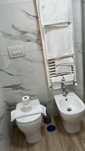 a white bathroom with a toilet and a sink at B&B La Terrazza in Cotronei