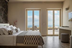 um quarto com uma cama e vista para o oceano em Almarossa Luxury Villas em Vourvoúlos