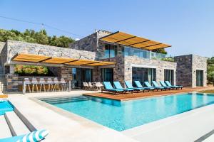 a villa with a swimming pool and a house at Villa Ektoras in Plaka +66 photos