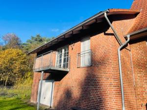 um edifício de tijolos com uma varanda ao lado em Ferienwohnung Edental em Burgdorf