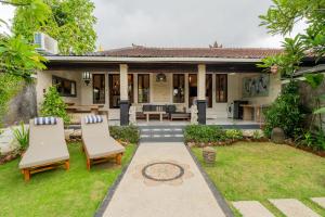 ヌサドゥアにあるPeaceful Tranquil Villa in Nusa Duaの庭園と椅子2脚付きの家