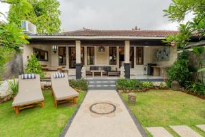 une maison avec un jardin et deux chaises dans l'établissement Sama Sama Villa, à Nusa Dua