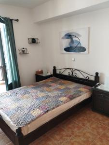 1 dormitorio con 1 cama con edredón en On the sea 2, en Mókhlos