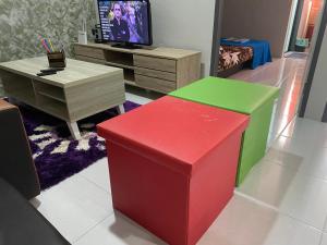 a living room with colorful furniture and a tv at The Time in Kota Samarahan