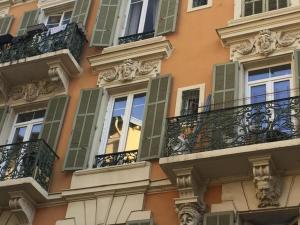 a building with green shutters and balconies on it at Hypercentre Nice Jean Medecin in Nice
