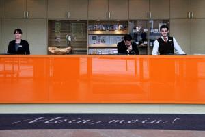 three people sitting at a counter in a store at Atlantic Hotel Kiel in Kiel