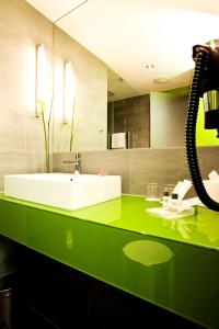 a bathroom with a green counter with a sink at Atlantic Hotel Kiel in Kiel