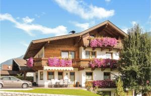 dom z fioletowymi kwiatami na balkonach w obiekcie Ferienwohnung In Aschau w mieście Aschau