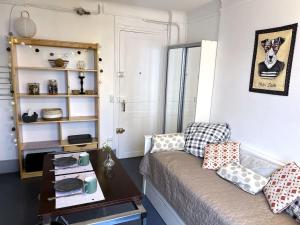 een woonkamer met een bank en een tafel bij Studio proche transports in Choisy-le-Roi