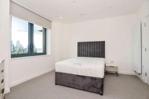 Habitación blanca con cama y ventana en Luxury 2 Bedroom Apartment East London, en Londres