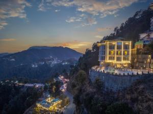 um edifício ao lado de uma montanha à noite em Echor Shimla Hotel - The Zion em Shimla
