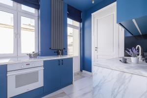 eine blaue Küche mit blauen Wänden und weißen Arbeitsflächen in der Unterkunft Apartment in Cracow Center with Air Conditioning, Desk and Balcony by Renters in Krakau