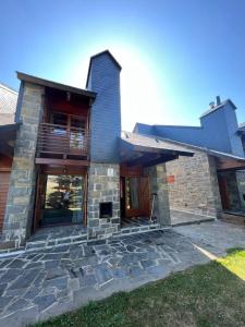 Cette maison en pierre dispose d'une terrasse couverte et d'un balcon. dans l'établissement Chalet Los Ibones - Lodge Formigal, à Formigal