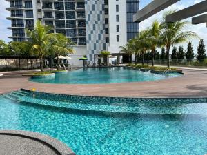 a large swimming pool with palm trees and buildings at Homestay KLGCC KL Golf Country Club Senada Residences in Kuala Lumpur