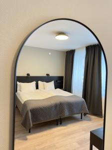 セーデルハムンにあるFirst Hotel Stattのベッドルーム(ベッド1台、大きな鏡付)