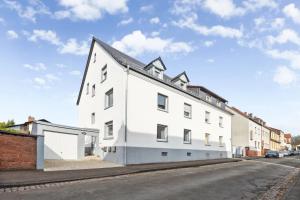 a white building on the side of a street at ANDRISS - Serviced Apartments I Workstations I WIFI in Kaiserslautern