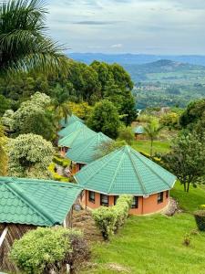 a group of houses with green roofs at Top of the World Lodges Fort Portal in Fort Portal