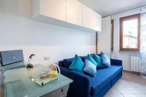 un sofá azul con almohadas azules en la sala de estar. en casa serena a Carmignano (Seano) vicino a Firenze, en Seano