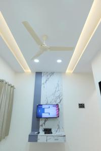 a ceiling fan in a room with a tv at SEVEN HILLS Guest House in Akalkot