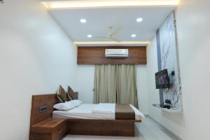 SEVEN HILLS Guest House في Akalkot: غرفة نوم صغيرة مع سرير مع إمكانية تلافي الأذان TRATRONSTIONSTRISTIONS