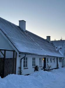 una casa blanca con nieve delante en Charmerende landsted med privat skov, en Bjergby