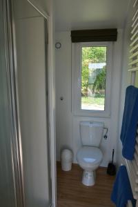 a bathroom with a toilet and a window at Ferienhaus Leipzig am Schladitzer See in Rackwitz