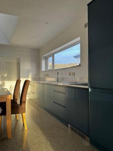 una cucina con lavandino, tavolo e finestra di Prospect View Unit A a Portstewart