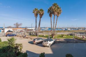 two cars parked in a parking lot with palm trees at Marzamemi Porto in Marzamemi