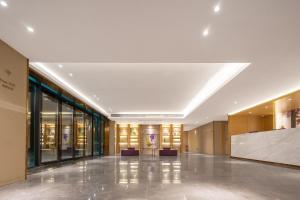 een lobby van een gebouw met banken en ramen bij Guangzhou Baiyun Airport Yunzhi Hotel near Terminal One in Guangzhou