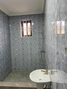 een badkamer met een wastafel en een raam bij Serene Hostel in Aboman