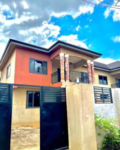 a house with a black garage in front of it at Serene Hostel in Aboman