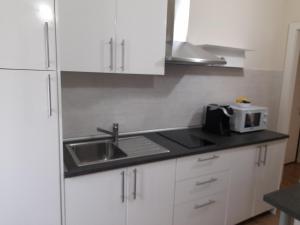 a white kitchen with a sink and a microwave at Ai Due Vecchi Ulivi in Garlate