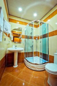 a bathroom with a shower and a toilet and a sink at Hotel & Bistro in Baku