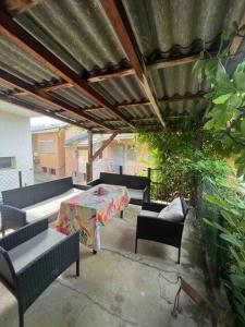 a patio with a table and chairs and a roof at Appartement Rosa au coeur des 4 Vallées in Conthey