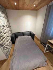 Cama en habitación con pared de piedra en Appartement Rosa au coeur des 4 Vallées, en Conthey