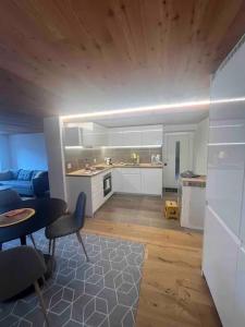 a kitchen and a living room with a table and chairs at Appartement Rosa au coeur des 4 Vallées in Conthey