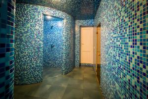 Un baño con paredes de azulejos azules y una puerta blanca. en Арніка, en Synevyrsʼka Polyana 49 fotos más