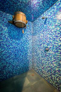 ein blau gefliestes Bad mit einem Fass an der Wand in der Unterkunft Арніка in Synewyrska Poljana