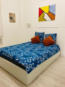 a bed with blue and white sheets and orange pillows at Studio récemment rénové proche gare et ville in Nice