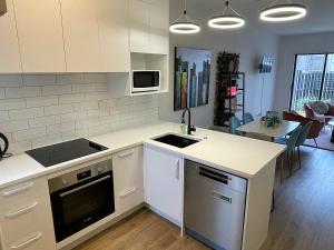 uma cozinha com um lavatório e um fogão forno superior em Flat Bush Holiday Accomodation em Auckland