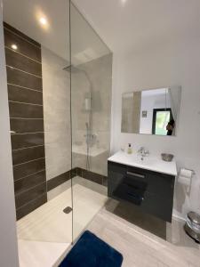a bathroom with a glass shower and a sink at Le Cherche Midi, entre Nîmes, le Pont du Gard, Uzès, Arles in Marguerittes