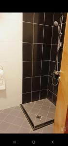 La salle de bains est pourvue d'une douche avec du carrelage noir et blanc. dans l'établissement شقق فندقية التلال, à La Mecque